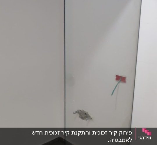 זכוכית מחיצה בחדר עם רצפת אריחים אפורה